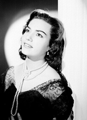 Rosa de Castilla, se apoya de espaldas a un muro, usa collar de perlas anudado, retrato