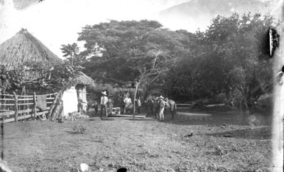 Hombres con caballos en el patio de una casa