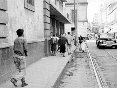 Mendigo camina por una acera