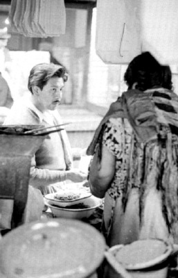 Mujer vende comida a hombre en el mercado La Merced