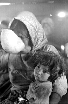 Mujer tarahumara bebe agua con bebé en brazos