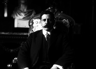 Félix Díaz vestido de traje en un sillón, retrato