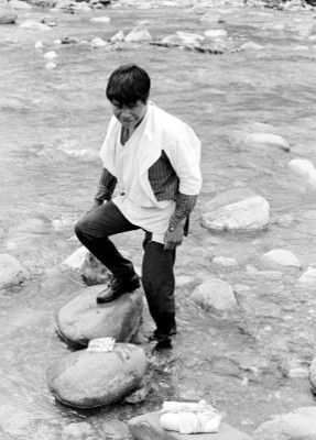 Indígena tzotzil sobre las piedras de un río