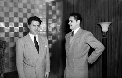 Alfonso Gaona dialogando con un hombre en una sala