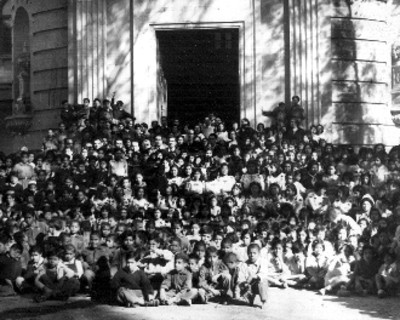 Ignacio Garcia Téllez con grupo de niños frente a un edificio