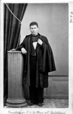 Hombre de pie junto a columna en estudio fotográfico