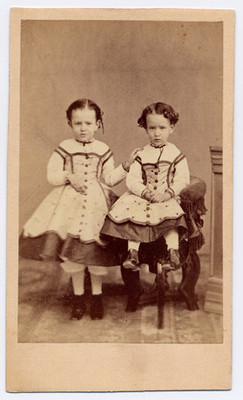 Par de niñas ataviadas con vestidos iguales, retrato