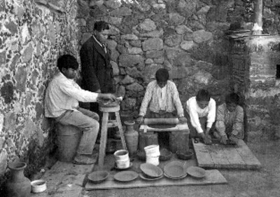 Hombre y niños en un taller fabrican utensilios de barro