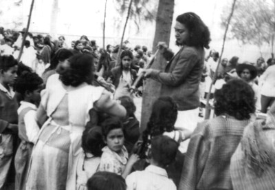 Mujer aplicando D. D. T. a una niña
