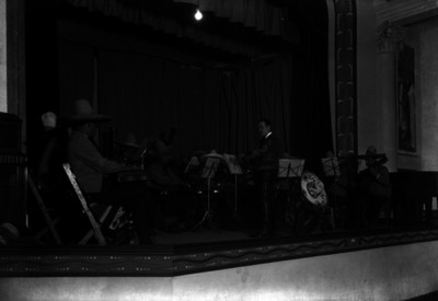 Miguel Lerdo de Tejada dirigiendo la Orquesta Típica Mexicana, en un teatro, durante un concierto