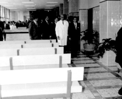 Adolfo López Mateos, Benito Coquet, José Alvarez Amézquita y médicos recorriendo sala de de espera de la clínica del IMSS Unidad Revolución, durante su inauguración