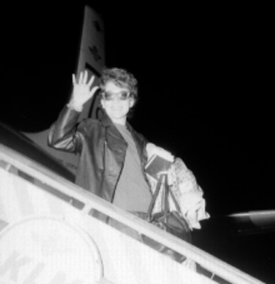 Mujer saludando desde las escaleras de un avión de la linea KLM