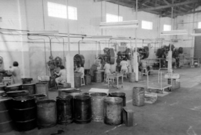 Trabajadores maniobrando maquinarias en la fábrica Mereles, S. A