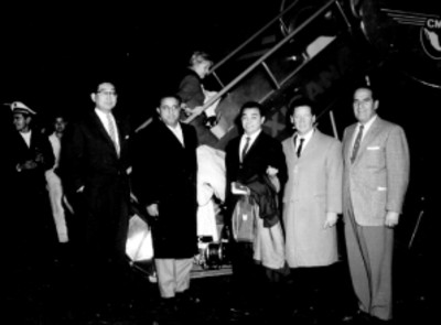 Trio los Panchos en compañía de otros individuos frente a un avión de Mexicana