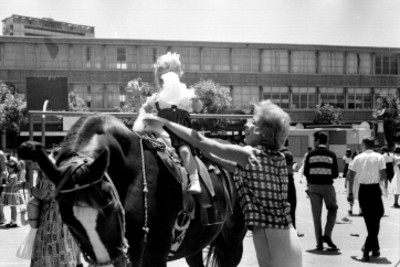 Mujer trepando a niña a un caballo en la feria organizada por la Commins de México