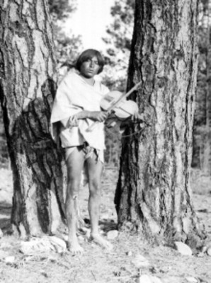 Hombre Tarahumara tocando un violín en un bosque, retrato