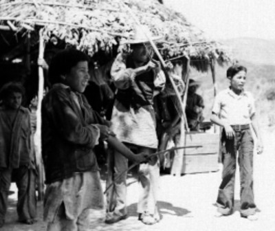 Yaqui tirando con arco y flecha en una aldea