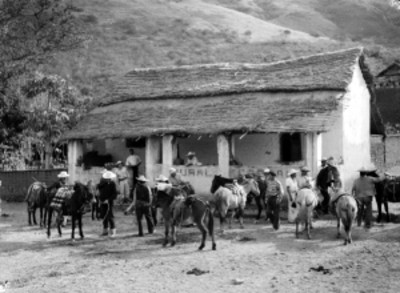 Exploradores con caballos, frent a una escuela rural federal en una rancheria de Nayar