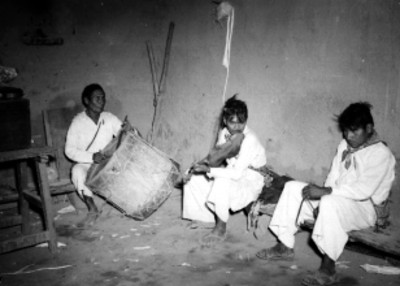 Músicos indígenas tocando en el interior de una casa rústica en Nayar