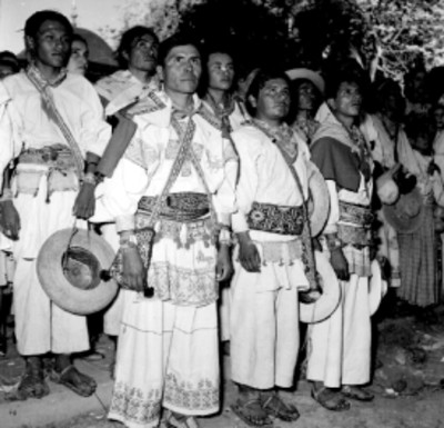 Hombres, mujeres y niños huicholes en una calle