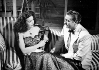 María Félix y un actor conversando en una sala, escena de película