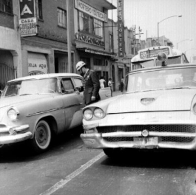 Patrulla tránsitando en una calle, probablemente deteniendo a un hombre