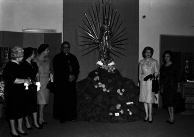 Miguel Darío Miranda y Gómez acompañado por varias mujeres junto a una imagen Guadalupana, al parecer durante una exposición, retrato de grupo