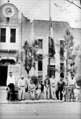Gente del pueblo junto al asta bandera de la Presidencia Municipal