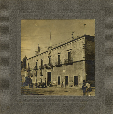 Personas caminan frente a la "Casa del corregidor [Miguel] Domínguez"