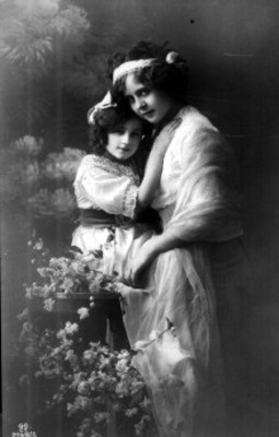 Mujer y niña abrazadas entre flores, retrato