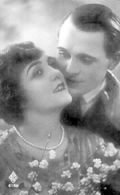Hombre junta su mejilla a la de una mujer, retrato, tarjeta postal