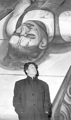 David Alfaro Siqueiros cerca de una pintura mural, retrato