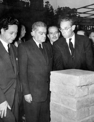 Gilberto Loyo con empresarios observa material para construcción durante una exposición