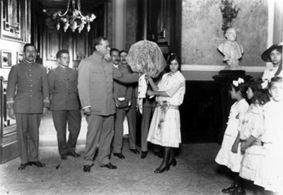 Venustiano Carranza recibe flores de manos de niña, en Palacio Nacional