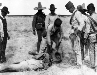 Soldados federales levantan cadáveres del campo de batalla