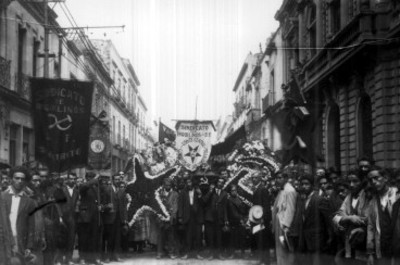 Hombres cargan un feretro durante un recorrido por las calles