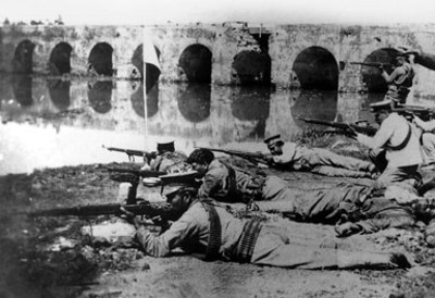 Soldados en posición de combate cerca de un puente