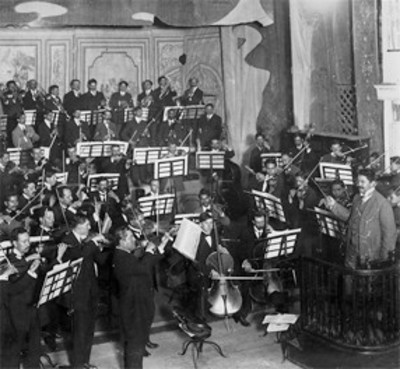 Julián Carrillo dirige orquesta durante concierto
