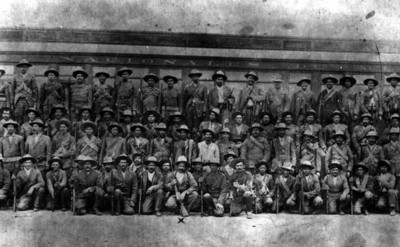 Francisco Villa y su Estado Mayor frente vagón de ferrocarril, retrato de grupo