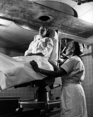 Enfermera observa a mujer durante la realización de un estudio médico