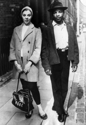 Mujer junto a hombre negro en una calle, retrato
