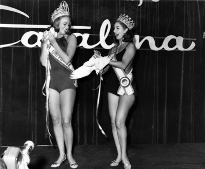 Reinas de belleza sostienen palomas durante concurso