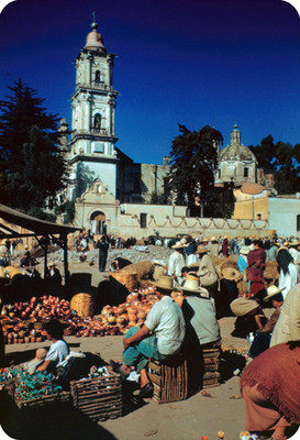 Gente en un tianguis, al fondo el Templo del Carmen