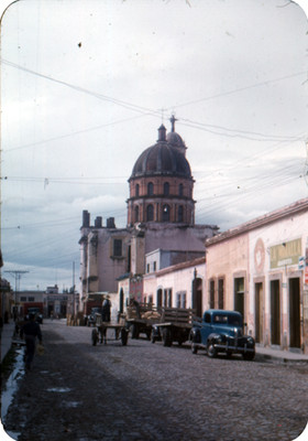 Vida cotidiana en una calle, al fondo el Templo de la Merced