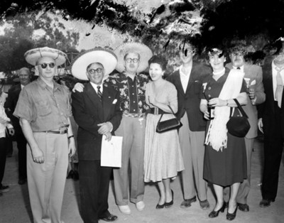 Personas portan sombreros regionales en plaza pública, retrato de grupo