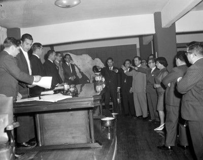 Ejecutivos protestan ante mesa directiva durante asamblea en un salón