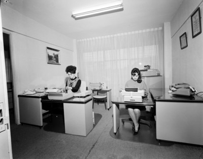 Secretarias trabajan con máquinas de escribir en una oficina