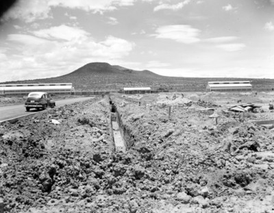 Trabajadores durante excavación a la orilla de una carretera, vista parcial