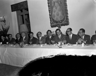 Hombres en comedor durante banquete en salón