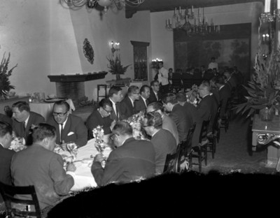 Hombres en comedores durante banquete en salón